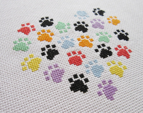 Stitched image of smaller paw print heart cross stitch pattern, at an angle