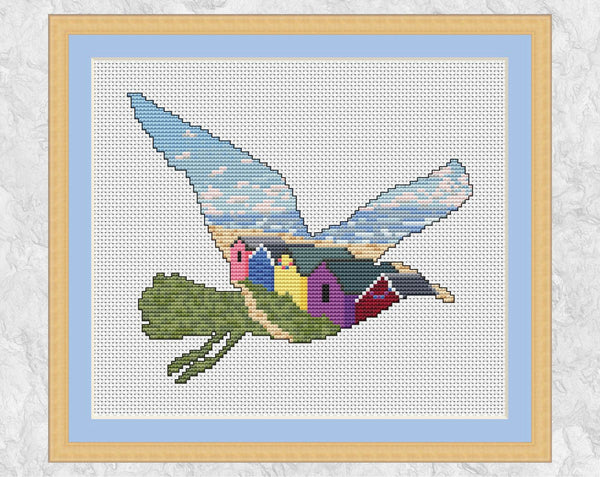 Cross stitch pattern PDF of a seagull filled with a scene of the sea, beach and beach huts. With frame.