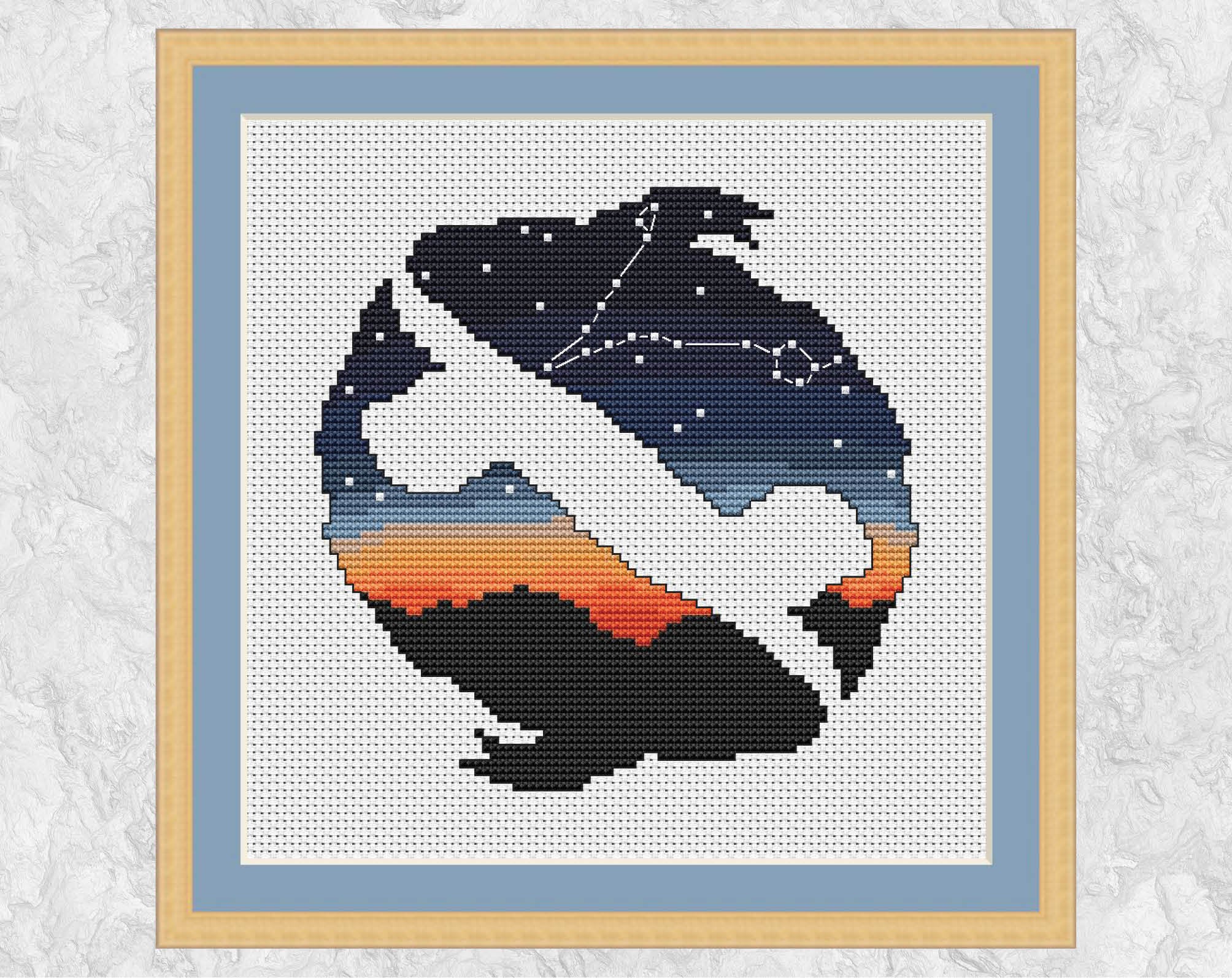 This cross stitch pattern shows the constellation of Pisces in the night sky, inside a silhouette of two fish, the symbol of Pisces. Shown with frame.