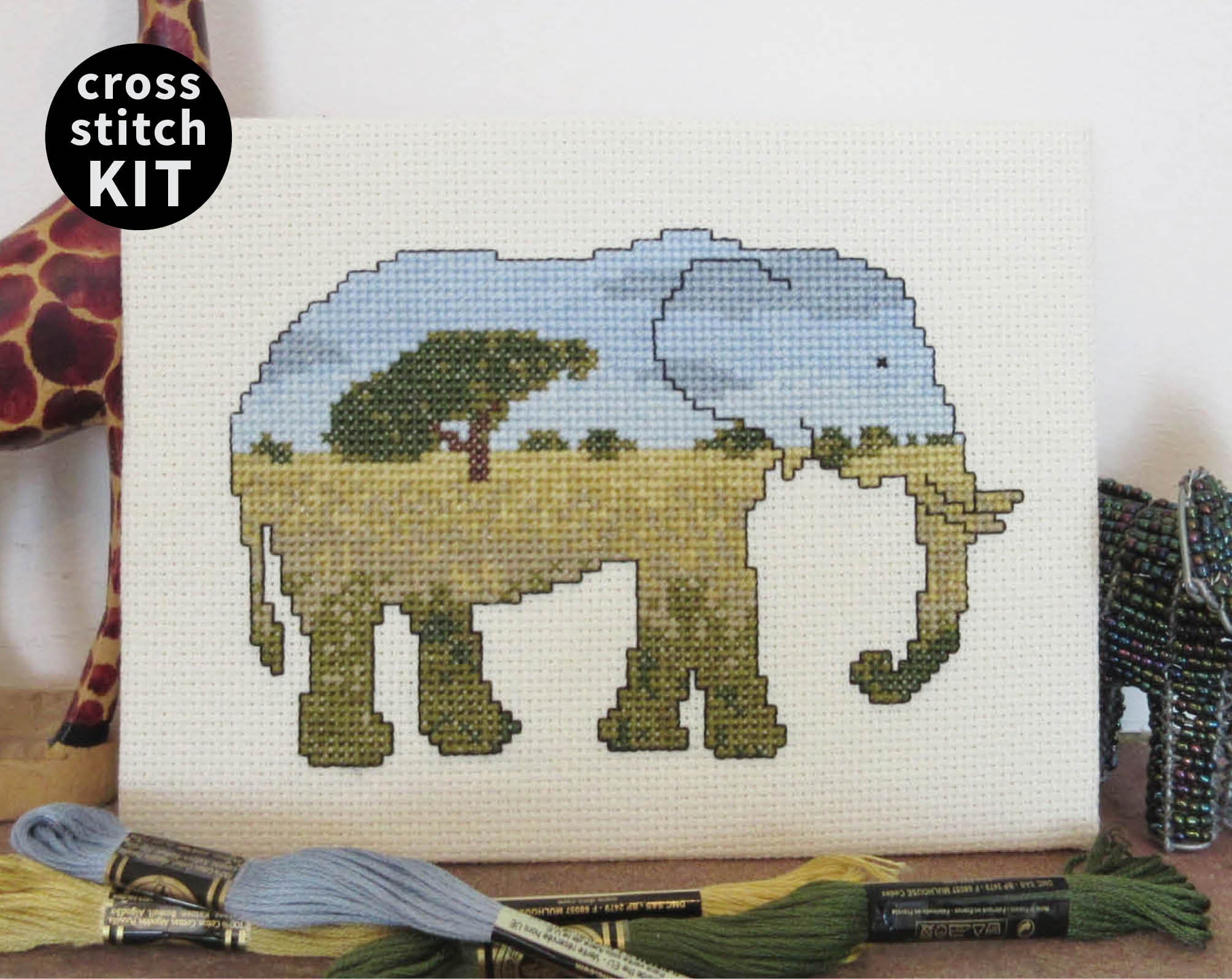 Elephant cross stitch kit - everything you need to stitch a silhouette of an elephant filled with a scene of the African savannah. Stitched piece with props.