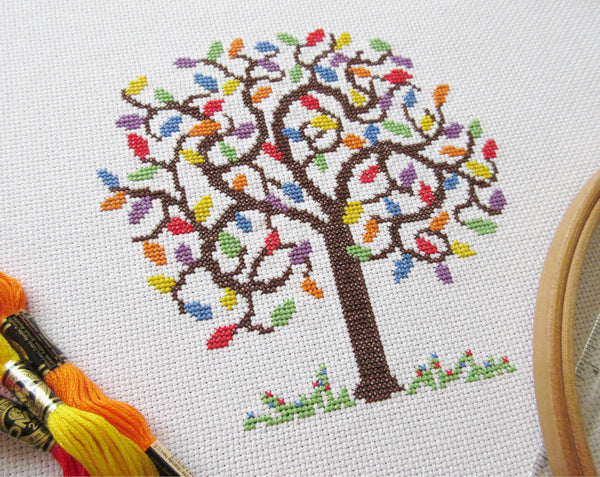 Rainbow Tree cross stitch pattern - angled view of stitched piece with props