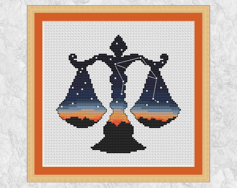 Cross stitch pattern of the silhouette of the weighing scales of Libra, filled with the last colours of the setting sun and with the constellation of Libra in the night sky. Shown with frame.