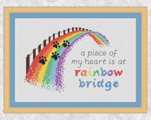 Cross stitch pattern of a rainbow bridge with the quote "a piece of my heart is at rainbow bridge". Shown with frame.