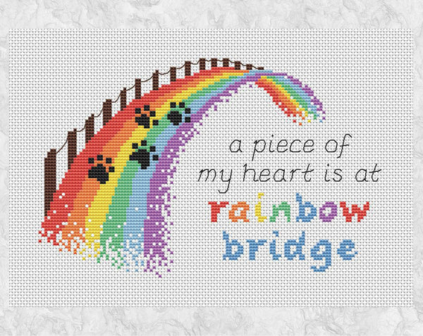 Cross stitch pattern of a rainbow bridge with the quote "a piece of my heart is at rainbow bridge". Shown without frame.