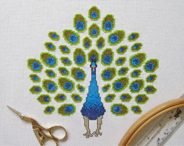 Peacock cross stitch pattern - stitched piece with props