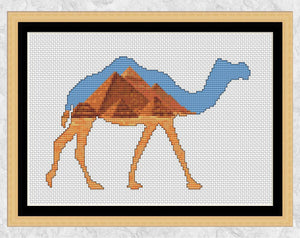 Cross stitch pattern of a camel silhouette filled with a desert scene of the famous Pyramids in Egypt. Shown with frame.