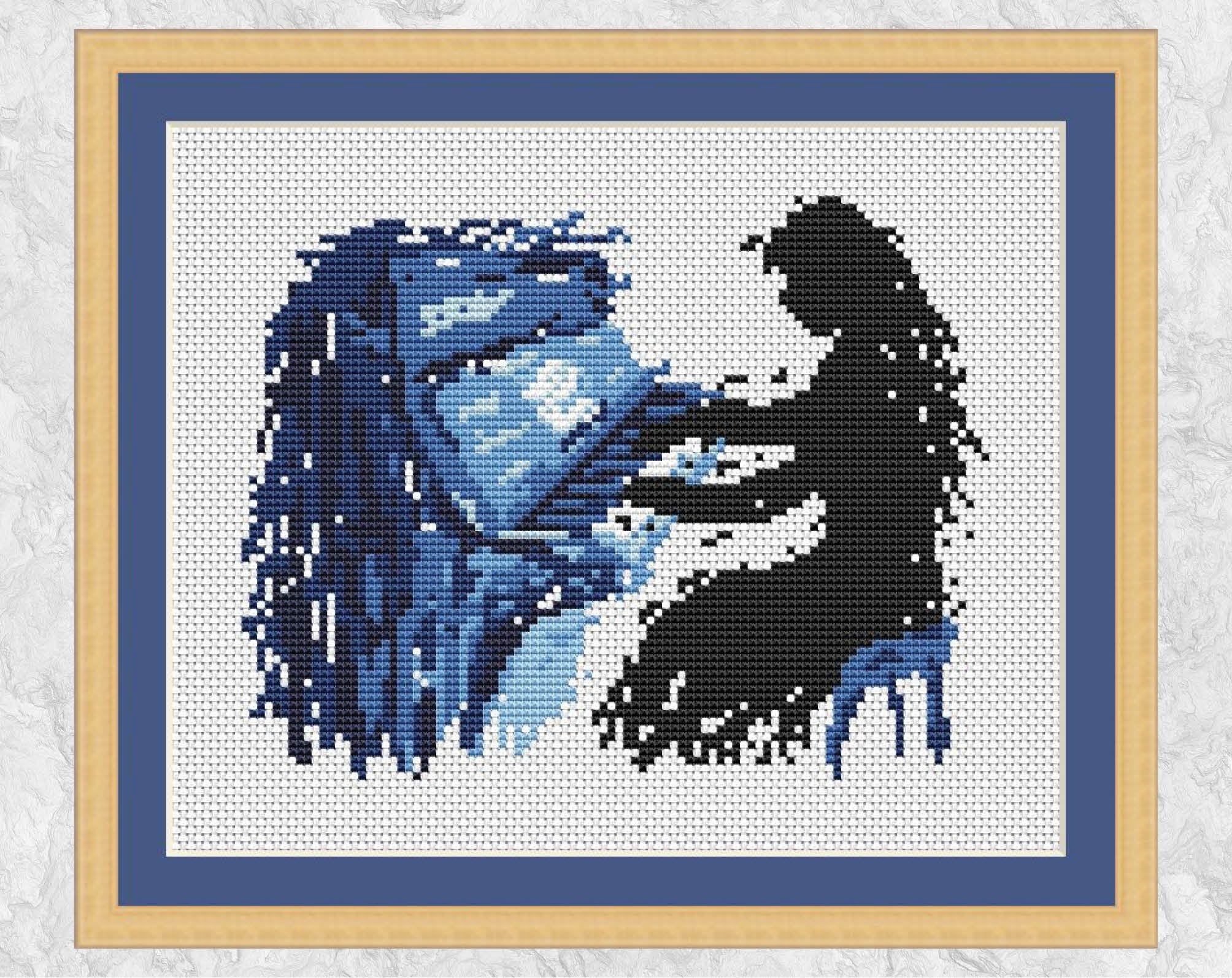 Splattered paint female piano player cross stitch pattern. Shown with frame.
