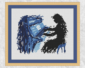 Splattered paint female piano player cross stitch pattern. Shown with frame.