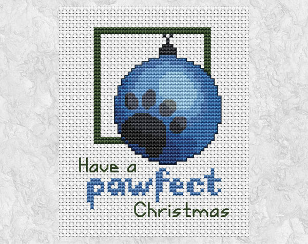 Cross stitch pattern of a blue bauble with a grey paw print on it, with the words 'Have a pawfect Christmas'. Shown without frame.