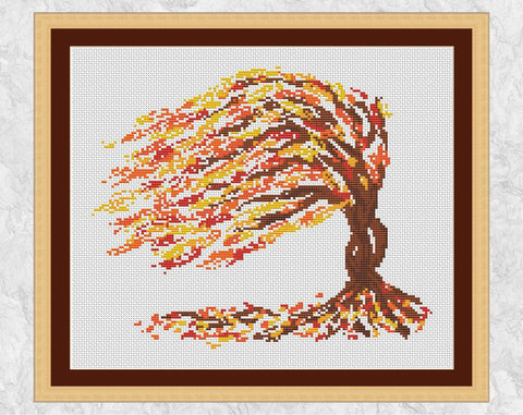 Colourful modern cross stitch pattern of a tree in the autumn or fall gales - with frame