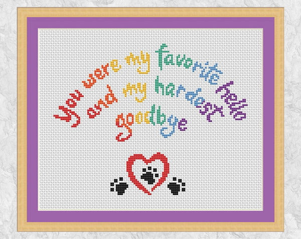 Cross stitch pattern of the words 'You were my favourite hello, and my hardest goodbye' in the shape of a rainbow, with a heart and paw prints. US spelling version in frame.
