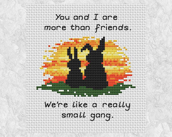 Cross stitch pattern of two bunny rabbits watching a sunset with the words 'You and I are more than friends. We're like a really small gang.' Shown without frame.