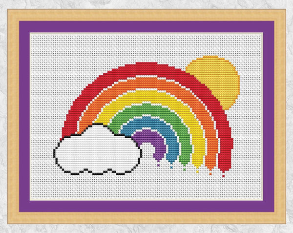 Cross stitch pattern of a rainbow, cloud and sun. Shown with frame.