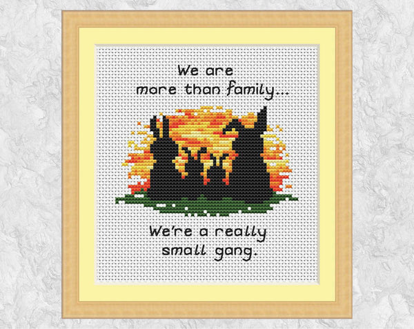 Cross stitch pattern of four bunny silhouettes against a sunset, with the words "We are more than family... We're a really small gang.". Shown with frame.