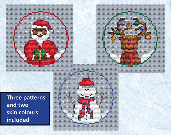 Set of three mini Christmas cross stitch patterns - Santa, reindeer and snowman. Shown without hoops with black-skinned Santa variation.