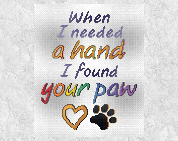 Cross stitch pattern of the words "When I needed a hand I found your paw", with a heart and paw print. Shown without frame.