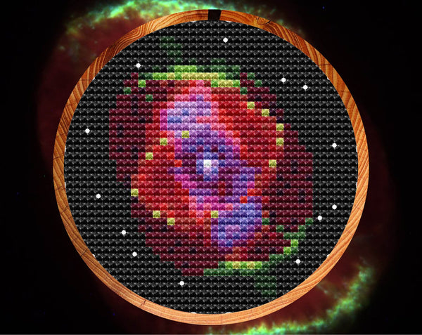 Cat's Eye Nebula cross stitch pattern in hoop with photo image background
