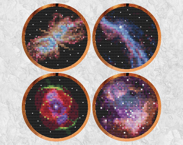 Set of four astronomy cross stitch patterns, showing the Butterfly Nebula, part of the Veil Nebula, the Cat's Eye Nebula, and part of the Small Magellanic Cloud. Shown in hoops against grey background.