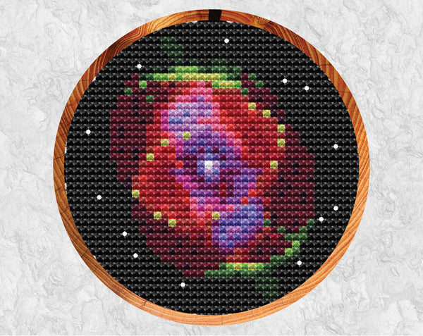 Cat's Eye Nebula cross stitch pattern in hoop with grey background