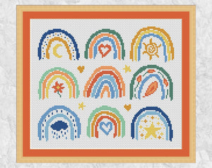 Cross stitch pattern of nine mini boho rainbows. Spring, summer, autumn and winter are all represented along with the stars and the moon. Shown with frame and orange mount.