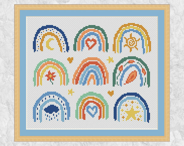 Cross stitch pattern of nine mini boho rainbows. Spring, summer, autumn and winter are all represented along with the stars and the moon. Shown with frame and blue mount.