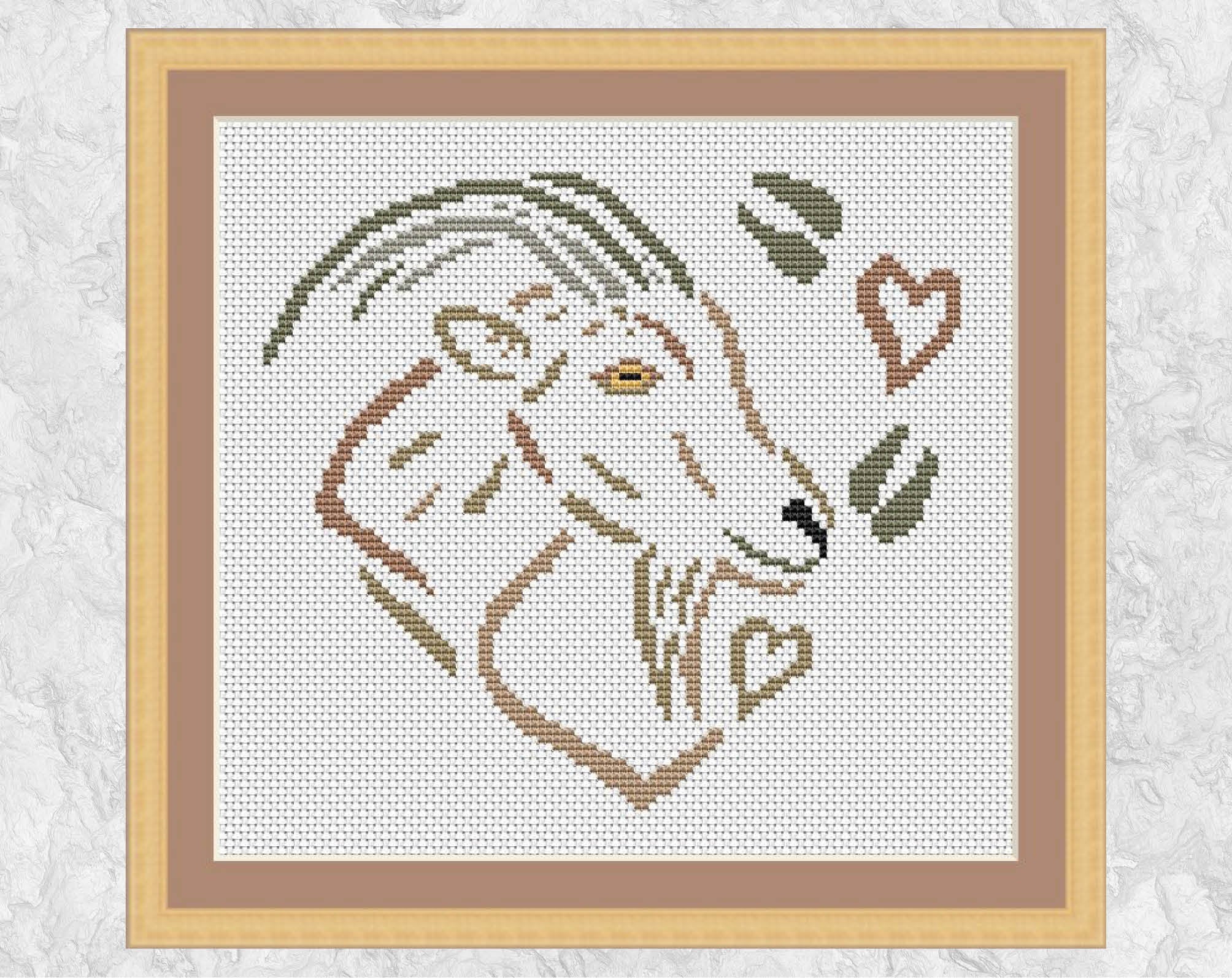 Cross stitch pattern of a goat, hearts and hoof prints, all forming a heart. Shown with frame.