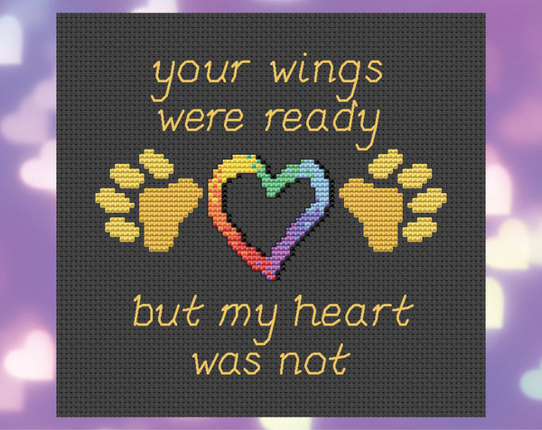 Pet memorial cross stitch pattern of the words 'Your wings were ready, but my heart was not', with paw prints and hearts. Shown without frame.