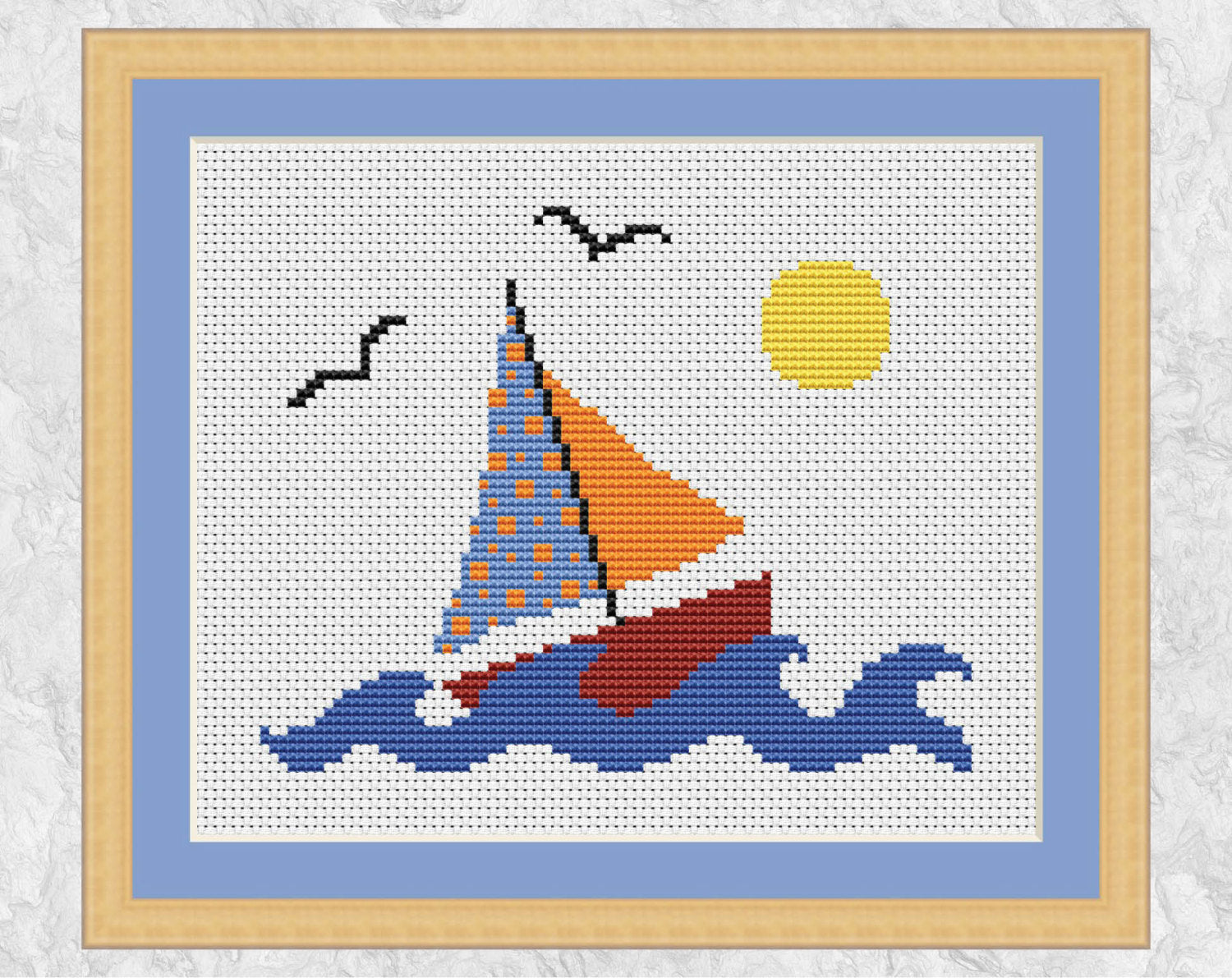 Cross stitch pattern of a sailboat out on the sea with waves, sun and birds. With frame.